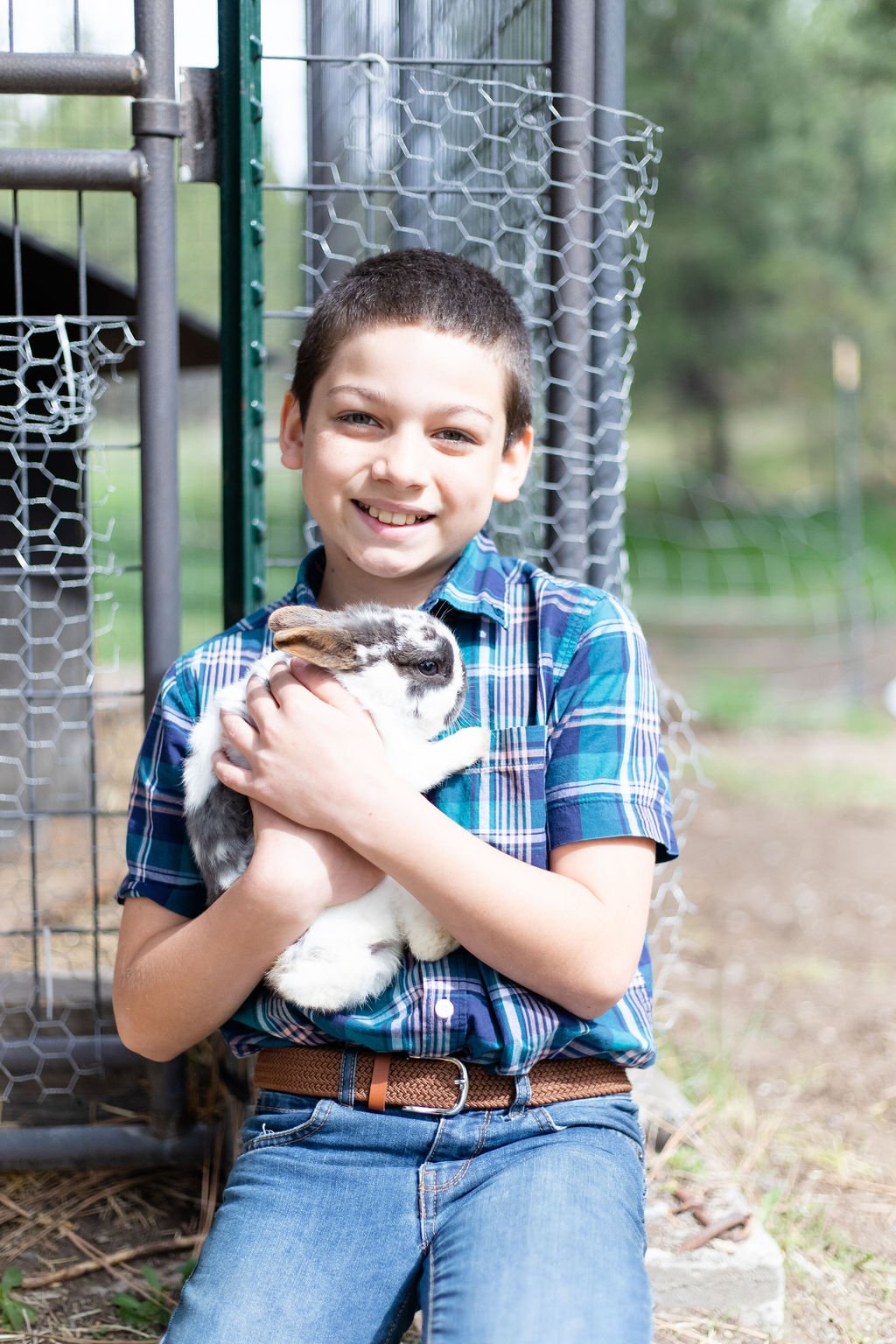 Child holding a rabbit inside the Raising Arrows Facility